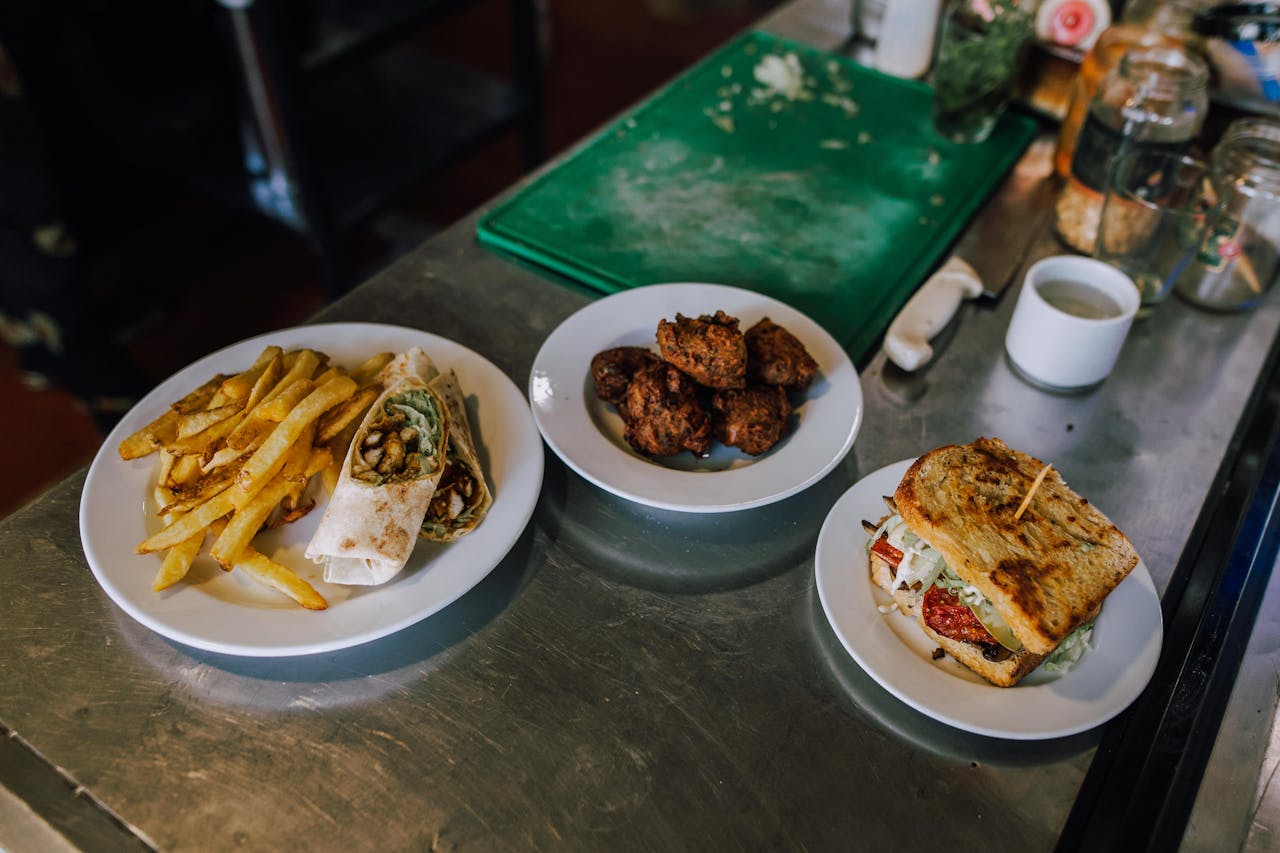 Top view of tasty Argentine meal with fries, sandwich, and meatball plate on a kitchen counter.